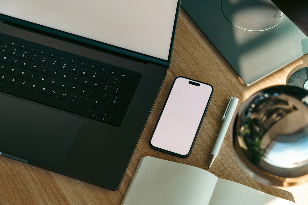 Laptop, phone and notebook on an organized desk for a digital declutter